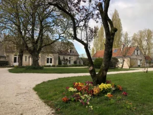 Jardin et allée en gravier devant les bâtisses du gite